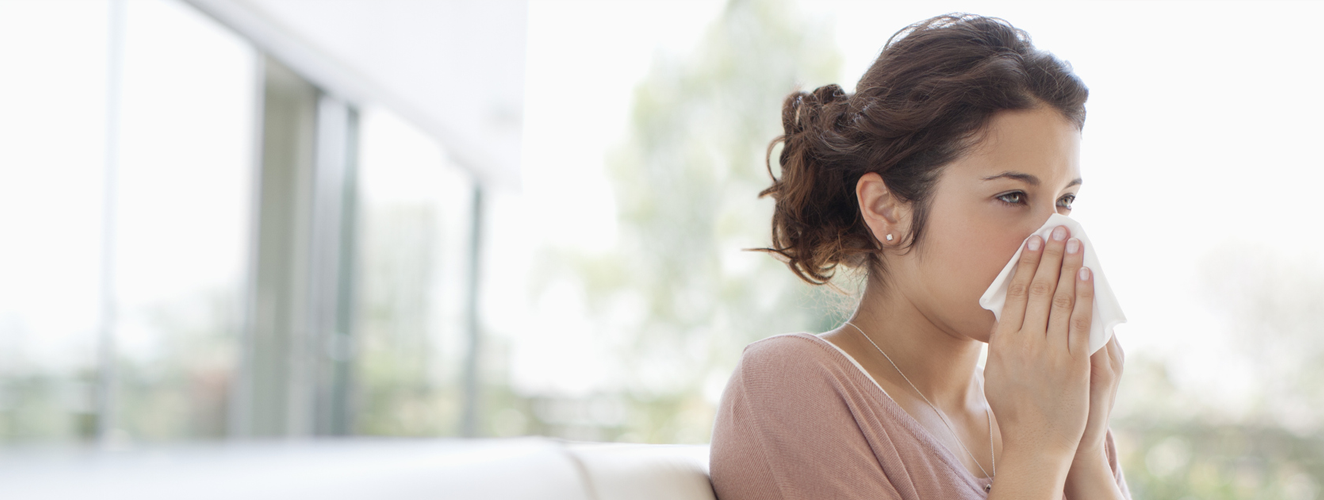 Sick woman blowing her nose | Doylestown Health